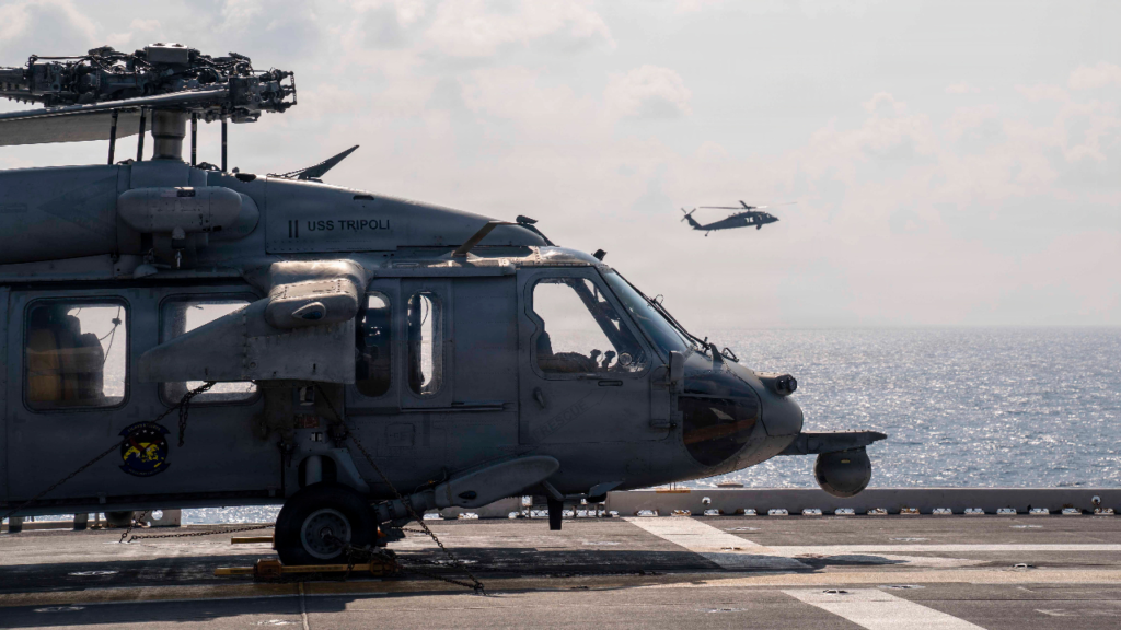 An MH-60S Seahawk helicopter sits chained on the deck of the USS Tripoli in the US Central Command area of responsibility, representing the lost aircraft that reveal how the Operation Epic Fury Costs contradict official statements.