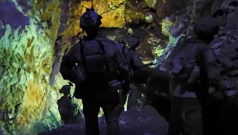 Hezbollah narrative recast defeat as attrition victory Soldiers in dark tactical gear move through a rocky tunnel lit by a greenish glow, a scene that echoes how the Hezbollah narrative reframes battlefield losses as a victory of attrition.