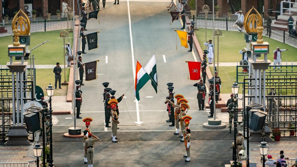 Gulf States Hedging Pairs Indian Trade With Pakistani Arms Indian and Pakistani border guards participating in the ceremonial flag-lowering at the Wagah border, symbolizing the diplomatic balancing act involved in Gulf States Hedging between South Asian powers.