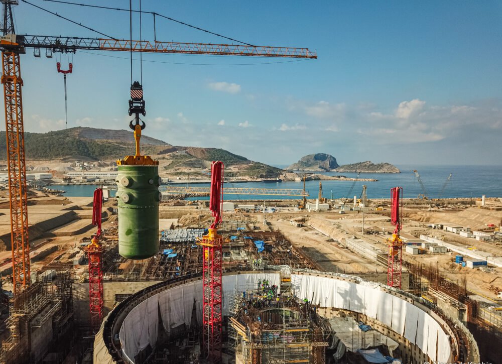 Turkey Nuclear Ambitions: A Bet on Ambiguity, Not the Bomb Aerial view of the Akkuyu Nuclear Power Plant under construction in Mersin, Turkey, with a massive green component lifted by cranes, symbolizing Turkey Nuclear Ambitions as a bet on ambiguity, not the bomb.