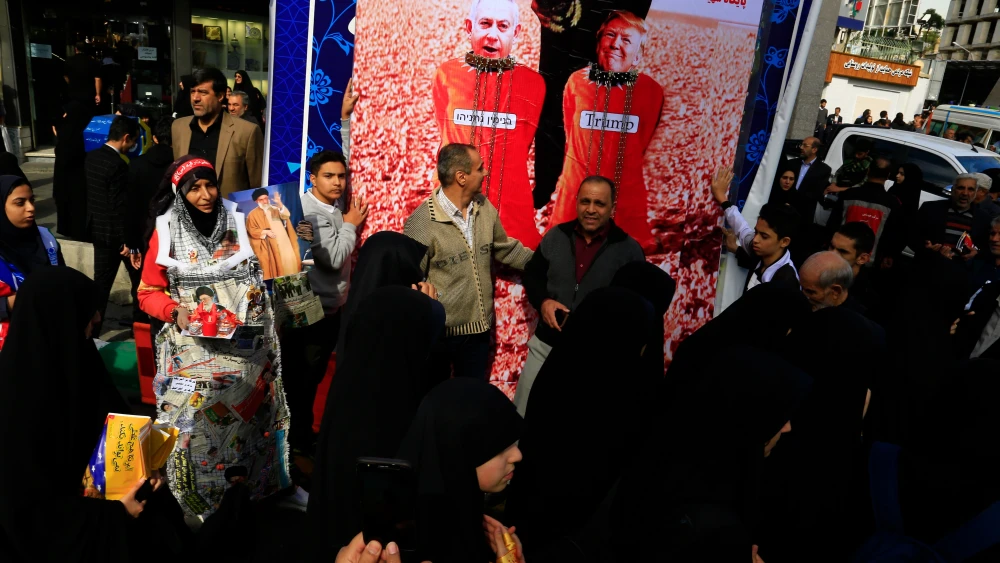 Iranian Jews Must Prove Their Jewishness Is Harmless A street scene in Tehran showing women in black chadors walking past a large political banner depicting US President Donald Trump and Israeli Prime Minister Benjamin Netanyahu in red targeting crosshairs, illustrating the hostile environment stoked by the Islamic Republic that forces Iranian Jews to constantly prove their Jewishness is harmless amid rising anti-Israel sentiment.