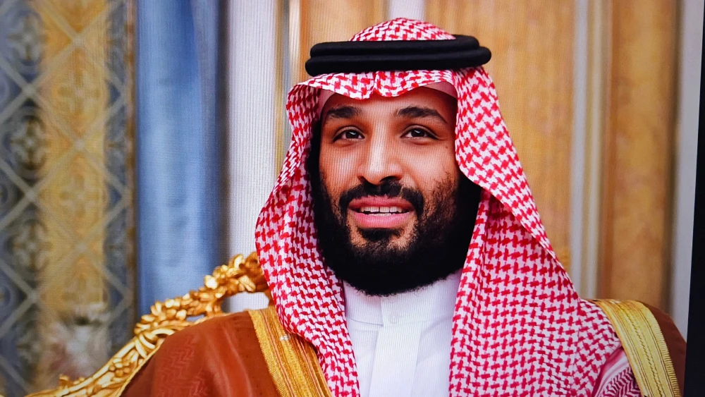 فشار تأمین مالی جنگ عربستان بر آرمانهای چشمانداز ۲۰۳۰ A close-up photograph of Saudi Crown Prince Mohammed bin Salman smiling in traditional red-and-white headwear and a gold-trimmed bisht, representing the outward confidence of the kingdom's leadership, even as its heavy spending on Saudi War Financing squeezes the funding required for his ambitious Vision 2030 economic transformation.