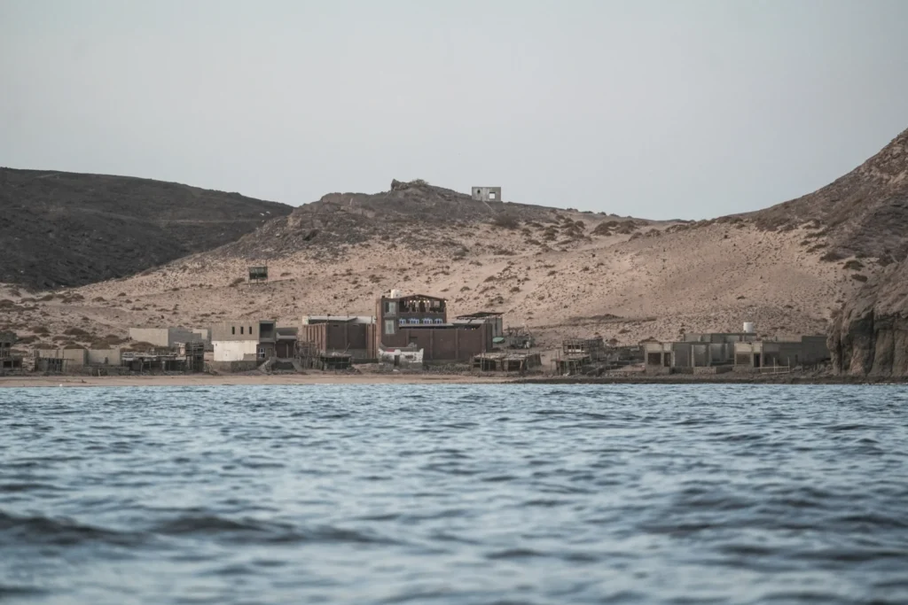 Coastal village on the arid Red Sea shoreline reflecting the Fall of Bab al-Mandab.