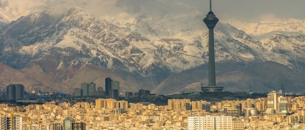 The Milad Tower rises above Tehran’s sprawling, sandy-colored cityscape beneath the snow-capped Alborz mountains, a vast and complex terrain where an Iran insurgency could outlast a US military victory.
