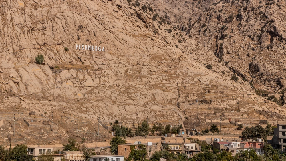 توحيد البيشمركة: سراب يجب على واشنطن أن تراه بوضوح White letters spelling "Peshmerga" on a barren mountainside above the village of Akre in Iraq's Kurdistan Region, a visual reminder of the Peshmerga Unification that Washington must see through as a mirage.