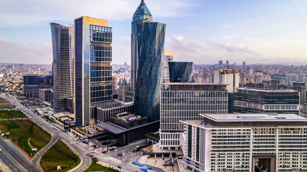 پول نفت ایران نقش بانکداری سایه ترکیه را آشکار میکند An aerial photograph showing the high-rise glass towers of the Istanbul Financial Center against a dense cityscape, visually representing the sophisticated financial infrastructure that allegedly facilitates the flow of Iranian oil money through Turkey's unregulated shadow banking sector, exposing loopholes in global sanctions enforcement.