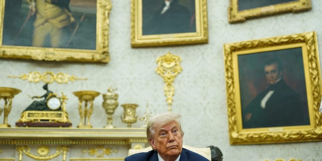 Donald Trump sits in an ornate room lined with gold-framed historical portraits and a mantelpiece of golden decor, his serious expression reflecting a moment of political strain and War Fatigue.