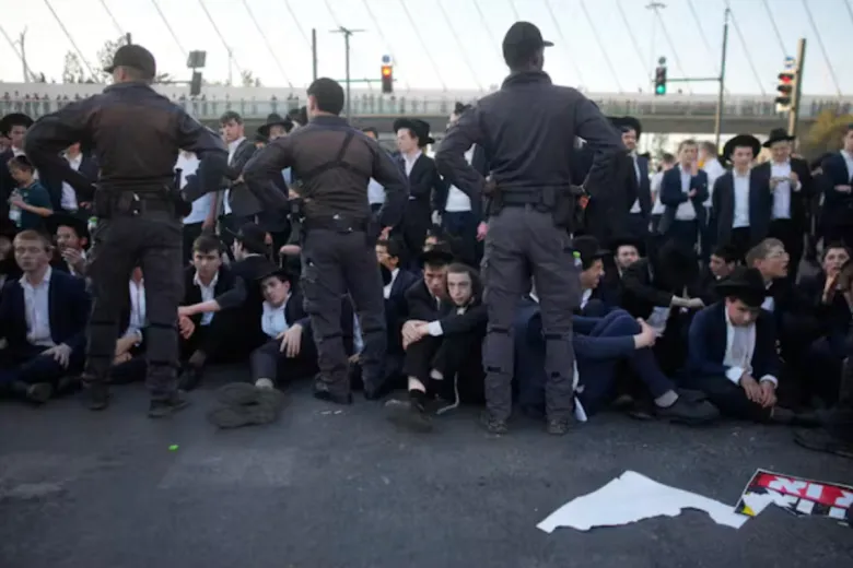 Haredi conscription fight now decides the fate of Netanyahu Israeli police officers standing over ultra-Orthodox Jewish protesters sitting on a street during a demonstration against mandatory military draft, illustrating political tensions over Haredi conscription.