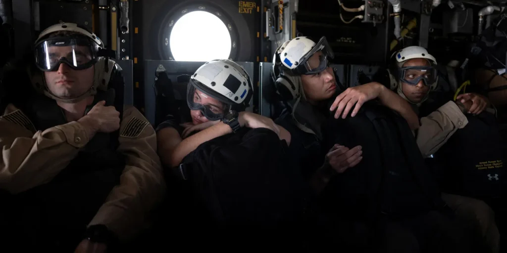 Hormuz Oil Traffic Recovers, but the Strait Remains in Limbo US military personnel equipped with flight helmets and goggles seated inside a transport aircraft during regional security patrols, reflecting lingering uncertainty around Hormuz Oil Traffic.
