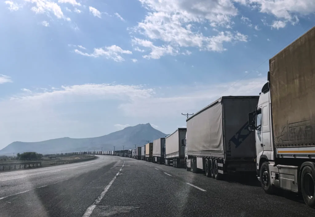 Iran Blockade Works, and Trump Must Not Cave A long line of cargo trucks queued at the Gurbulak border crossing between Turkey and Iran, illustrating the commercial disruption and trade impact of an effective Iran Blockade.