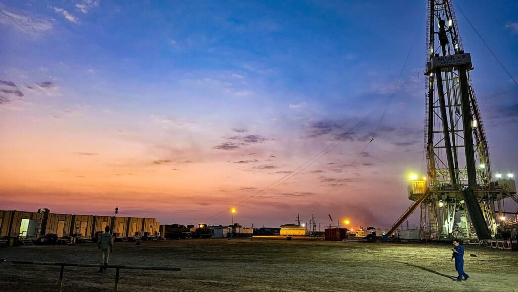 An industrial drilling rig at an Iraqi oil field during sunset, illustrating infrastructure challenges and export bottlenecks linked to the Kirkuk-Ceyhan pipeline.