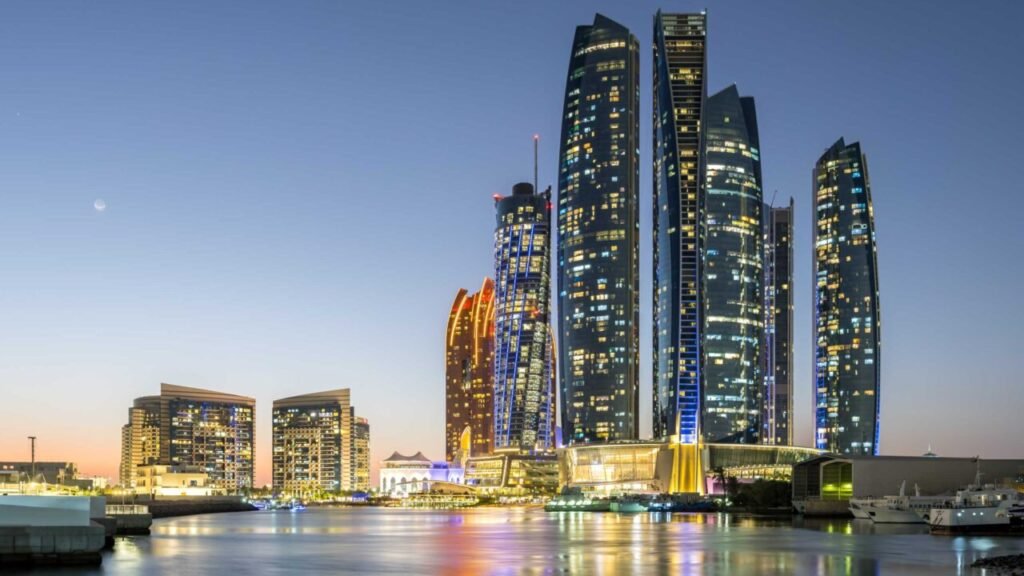 Modern illuminated skyscrapers along the United Arab Emirates waterfront at dusk, representing the infrastructure and economic resilience of the UAE Connectivity Model.