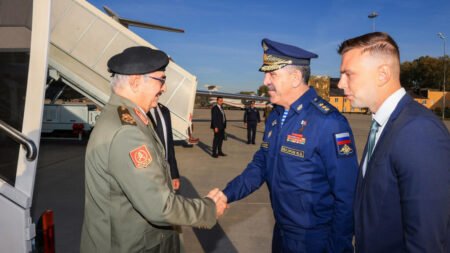Libyan commander Khalifa Haftar shaking hands with a Russian official, highlighting the threat of Russian Bases in Libya.