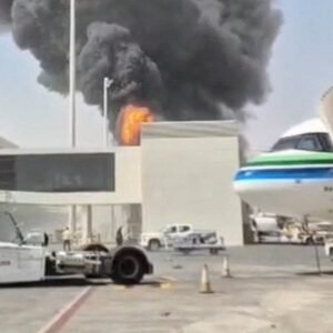 Black smoke and fire on an airport tarmac, illustrating the Saudi-Houthi Escalation that threatens to pull in Washington.