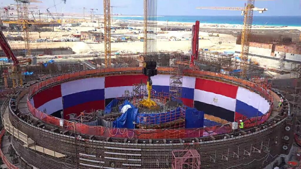 Nuclear Export Race Exposes a Fragmented American System Construction site of the Russian-backed El Dabaa nuclear power plant in Egypt lined with Egyptian and Russian flags, showcasing state-funded energy infrastructure in the global Nuclear Export Race.