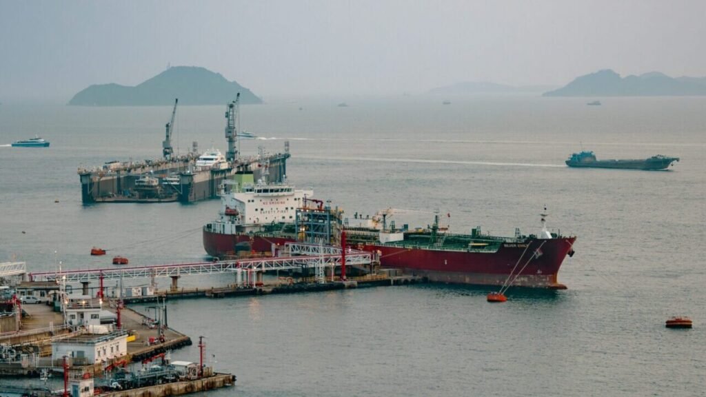 التجزئة الجيواقتصادية بعد إغلاق هرمز The oil tanker Silver Emily docked near the Hong Kong container terminal, illustrating energy trade realignment and Geoeconomic Fragmentation following the Strait of Hormuz closure.