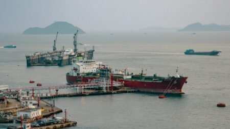 The oil tanker Silver Emily docked near the Hong Kong container terminal, illustrating energy trade realignment and Geoeconomic Fragmentation following the Strait of Hormuz closure.