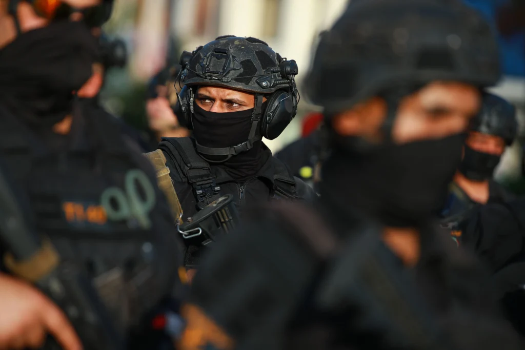 خروج ائتلاف: عراق شبهنظامیان را حفظ کرد، اما نفوذ را از دست داد Iraqi soldiers in black tactical gear and helmets standing in formation, illustrating security developments and militia dynamics following the US-led Coalition exit.