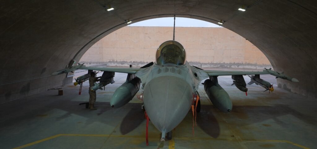 A Jordanian Royal Air Force fighter jet parked inside a reinforced concrete hangar, representing military readiness and regional security operations amid the Syria security vacuum.